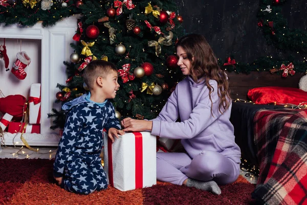 Красивая мать с сыном украшение елки с новогодними подарками — стоковое фото