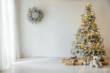 Evin içi beyaz Noel ağacı ışıklarıyla süslenmiş. Yeni yıl hediyeleri.