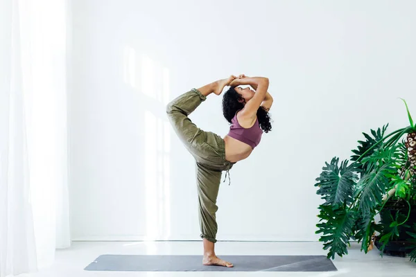 Frau Brünette macht Yoga Asana-Gymnastik in der weißen Halle — Stockfoto