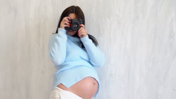 Mooie zwangere vrouw fotograaf met camera — Stockvideo