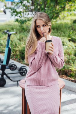 Güzel sarışın kadın pipetli sokak yemeğiyle içki içiyor.