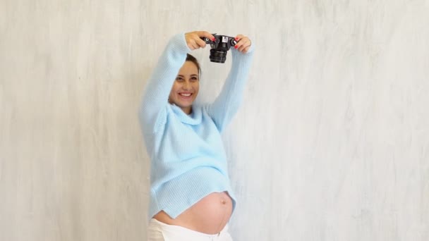 Красива вагітна жінка фотограф з камерою — стокове відео