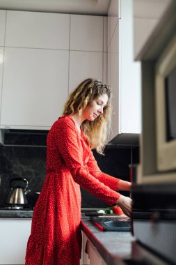 Kadın ev hanımı mutfakta taze sebze salatası hazırlar.