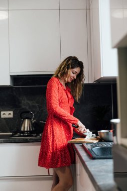 Kadın ev hanımı mutfakta taze sebze salatası hazırlar.