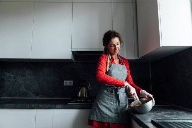 Kadın ev hanımı mutfakta tatlı kek hazırlıyor.