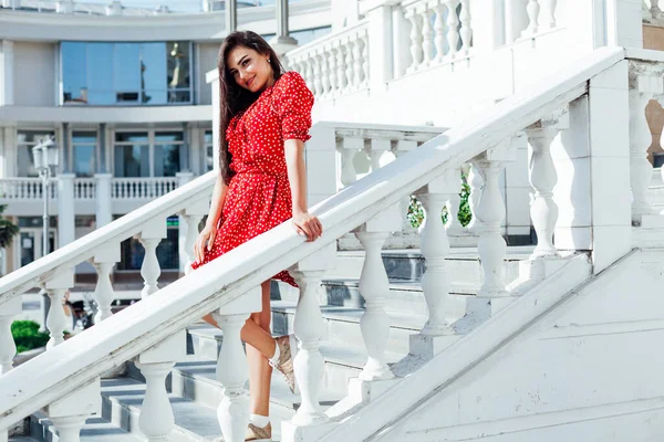 Όμορφη μελαχρινή γυναίκα το καλοκαίρι κόκκινο φόρεμα με τα πόδια έξω — Φωτογραφία Αρχείου