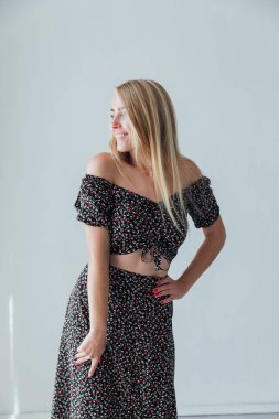 Gri elbiseli güzel sarışın bir kadının portresi.