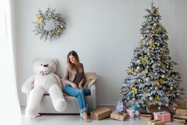 Noel ağacında oyuncak ayıyla güzel bir kadın.