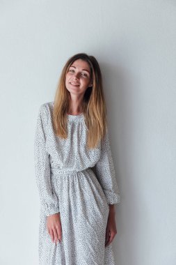 Açık beyaz portre elbisesi içinde sarışın güzel bir kadın.