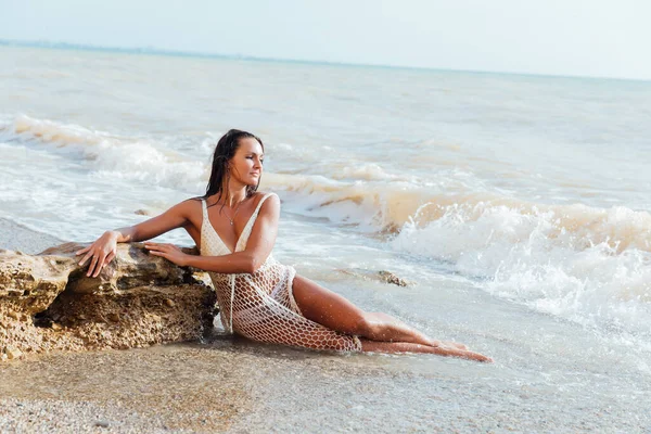 Krásná opálená žena v letních šatech na pláži u moře — Stock fotografie