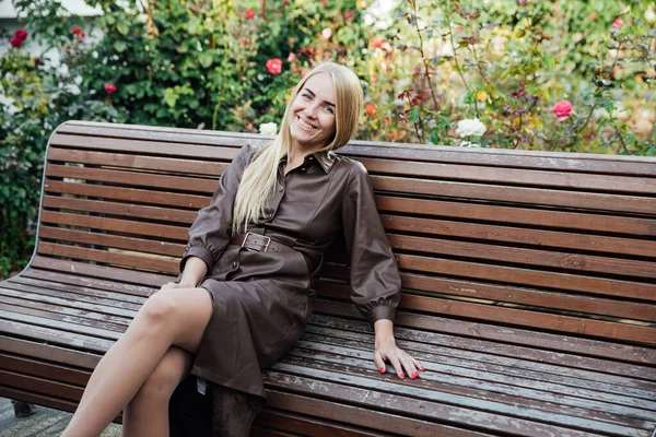 Beautiful blonde woman in a raincoat on the street of the city walk — 图库照片