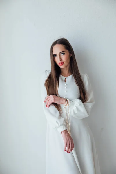 Πορτρέτο μιας όμορφης γυναίκας σε ένα ελαφρύ καλοκαιρινό φόρεμα σε λευκό φόντο — Φωτογραφία Αρχείου