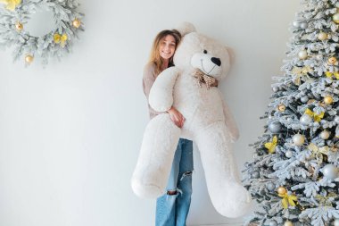 Noel ağacında oyuncak ayıyla güzel bir kadın.
