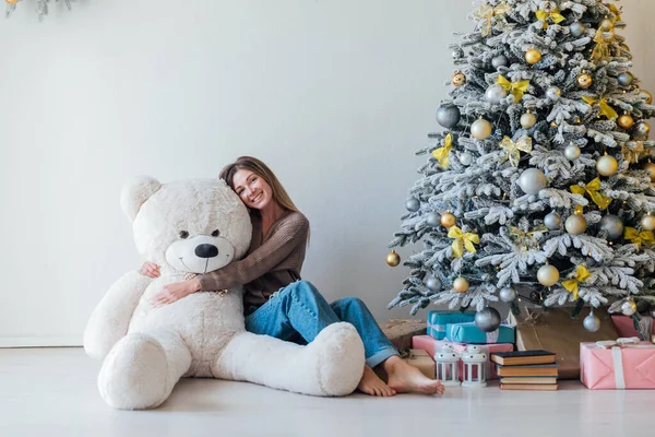 Noel ağacında oyuncak ayıyla güzel bir kadın.