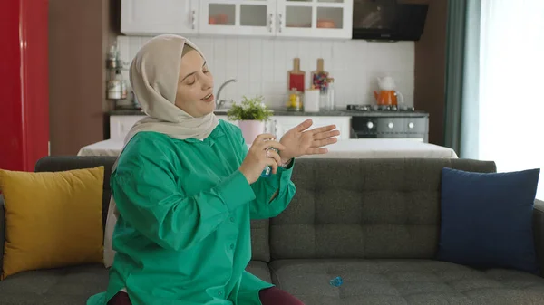 Young woman in hijab using her new perfume. Beautiful woman in hijab is applying perfume.