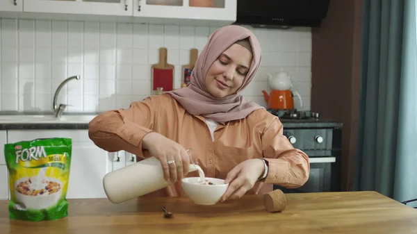 Feliz Musulmán Vestido Con Hiyab Sentado Mesa Cocina Casa Vertiendo — Foto de Stock