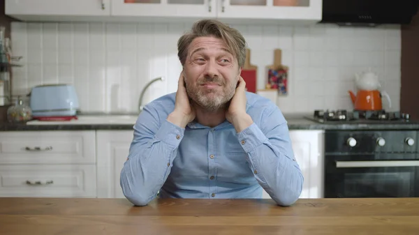 Unhappy depressed man. Stressed from work, worried, heartbroken. Thinking young man sitting alone in the kitchen.