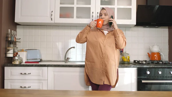 Mujer Joven Hijab Hablando Teléfono Inteligente Apoyado Mostrador Cocina Mujer — Foto de Stock