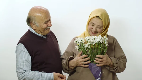 Tesettürlü Yaşlı Mutlu Kadına Kocası Bir Sürü Papatya Veriyor Beyaz — Stok fotoğraf