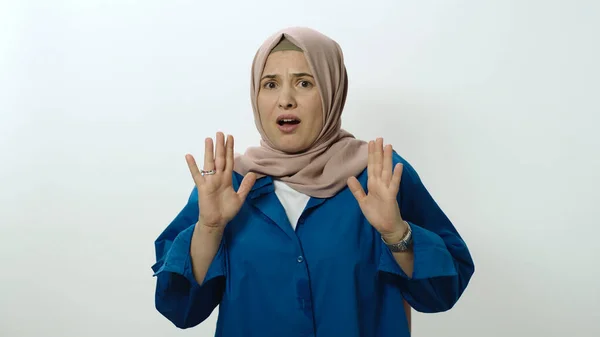 Sad, thoughtful young woman in hijab is afraid. Woman posing in studio portrait isolated on white background. Portrait showing shock gesture in face of surprise.