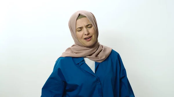 Angry, frustrated young woman in hijab is afraid. Woman posing in studio portrait isolated on white background. Portrait showing angry, frustrated and surprised gesture in face of surprise.