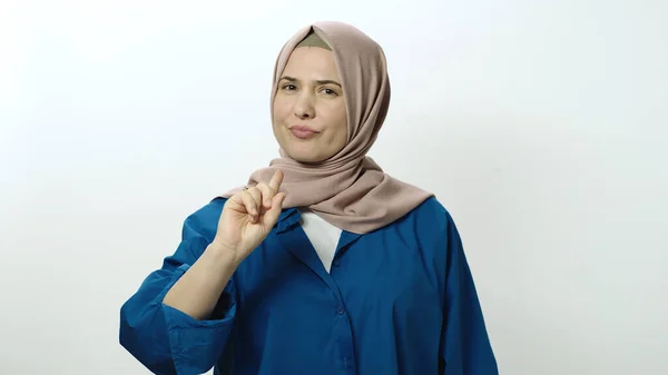 Angry, frustrated young woman in hijab is afraid. Woman posing in studio portrait isolated on white background. Portrait showing angry, frustrated and surprised gesture in face of surprise.