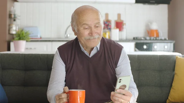 Velho Assistindo Vídeo Engraçado Seu Smartphone Enquanto Bebe Café Casa — Fotografia de Stock