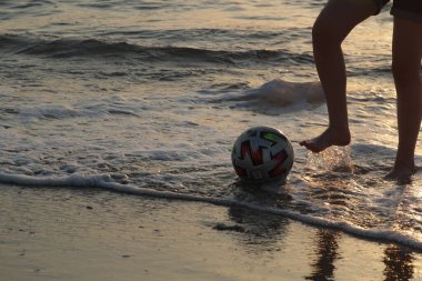 a man is playing with a ball on the beach
