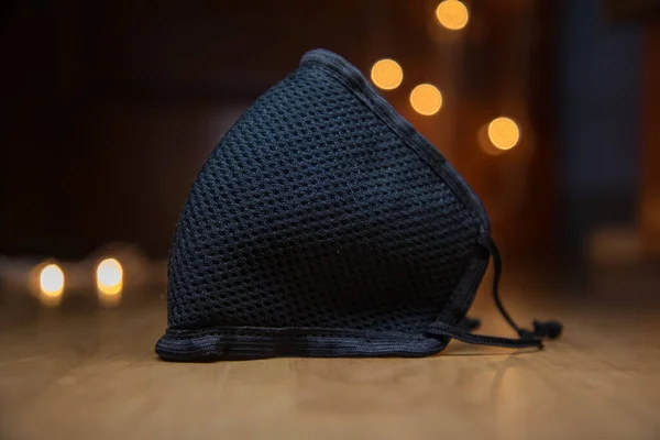 a surgical black face mask in bokeh effect