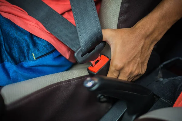 man holding a car seat belt for safety.