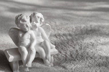 İki melek. Yedek kulübesinde ve turuncu topta melekler. Oyuncaklar alçıdan yapılır..                