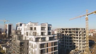 Yüksek kule vincinin ve inşaat halindeki apartmanların havadan görüntüsü. Gayrimenkul geliştirme.