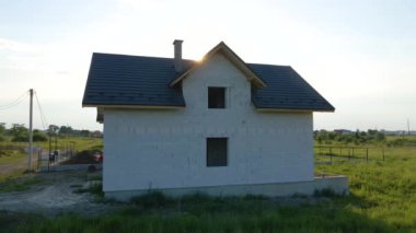 Havalandırması hafif beton duvarları ve inşaat halindeki metal çatısı olan özel bir evin tamamlanmamış iskeleti..