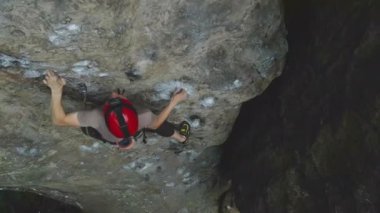 Güçlü erkek tırmanıcı kayalık dağın dik duvarına tırmanıyor. Sporcu zor yolu aştı. Ekstrem spor hobisi konsepti.