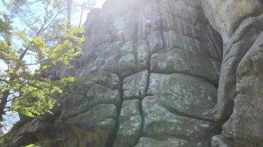 Güçlü çocuk kayalık dağın dik duvarına tırmanıyor. Genç çocuk zor yolu aşıyor. Ekstrem spor hobisi konsepti.