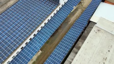 Temiz ekolojik elektrik üretmek için çatıya monte edilen mavi fotovoltaik güneş panellerinin hava görüntüsü. Yenilenebilir enerji konsepti üretimi.