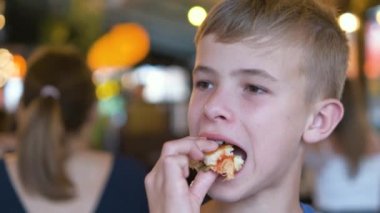 Çocuk restoranda lezzetli burger yiyor..