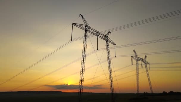 日の出時に電力線と高電圧塔の暗いシルエット — ストック動画