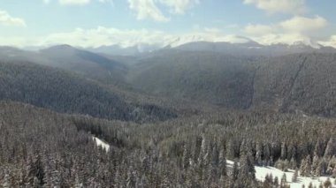 Soğuk, aydınlık bir günde şiddetli kar yağışı sonrası dağ tepeleri ile kaplı, kışın hava manzarası..