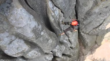Kayalık dağın dik duvarından inen güçlü erkek tırmanıcı. Sporcu zor yolu aştı. Ekstrem spor hobisi konsepti.