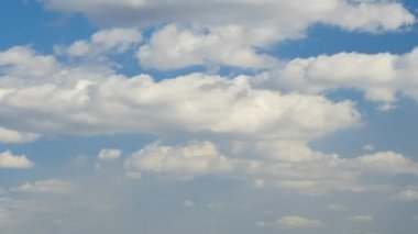 Mavi berrak gökyüzünde hızlı hareket eden beyaz bulutların hızlandırılmış görüntüleri.