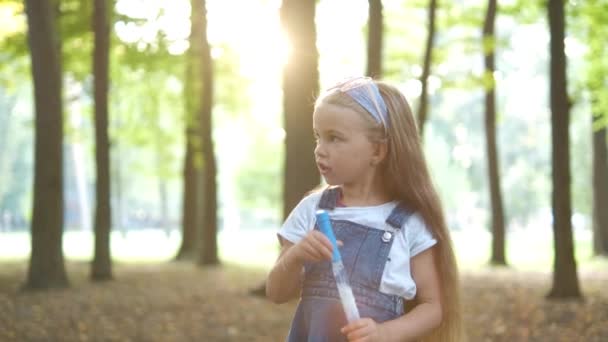 Kleines Glückliches Kindermädchen Pustet Seifenblasen Sommerpark — Stockvideo