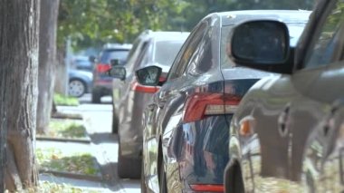 Sokak kenarında park halindeki arabalarla şehir trafiği.