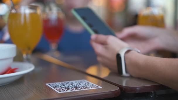Primer plano de la mano invitada encargando comida en el restaurante mientras escanea el código qr con el teléfono móvil para el menú en línea. — Vídeo de stock