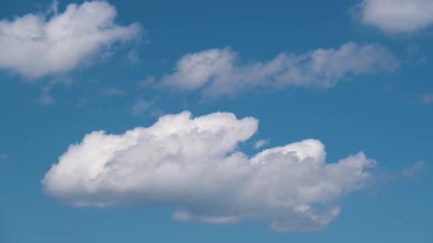 Mavi açık gökyüzünde hızlı hareket eden beyaz kabarık kümülüs bulutlarının hızlandırılmış görüntüleri. — Stok video
