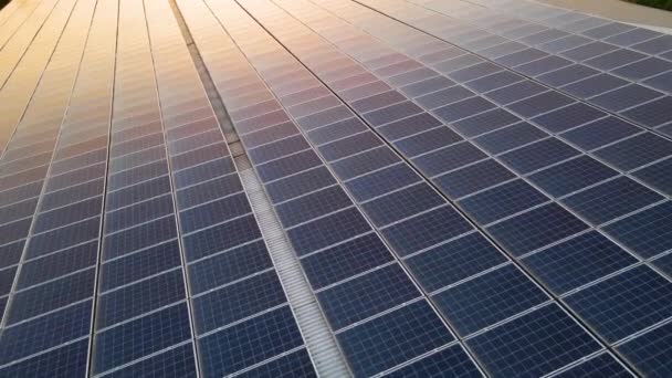 日没時にきれいな生態系電力を生産するための建物の屋根に取り付けられた青い太陽光発電パネル。再生可能エネルギーの概念の生産. — ストック動画