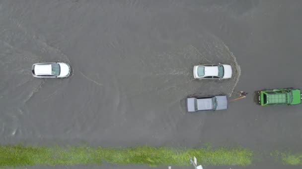 Luchtfoto van het stadsverkeer met auto 's rijden op overstroomde straat na zware regen. Problemen met het rioleringssysteem. — Stockvideo
