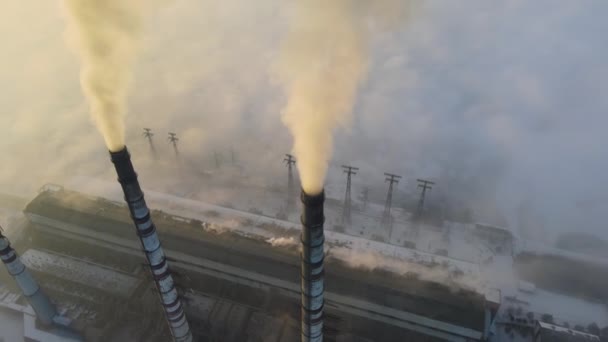 Vista aérea de tubulações altas da usina de carvão com fumaça preta que se move acima da atmosfera poluente no por do sol. — Vídeo de Stock