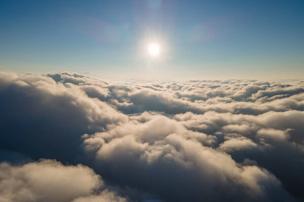 Воздушный вид из окна самолета на большой высоте плотных кучевых облаков, образующихся перед ливнем вечером.