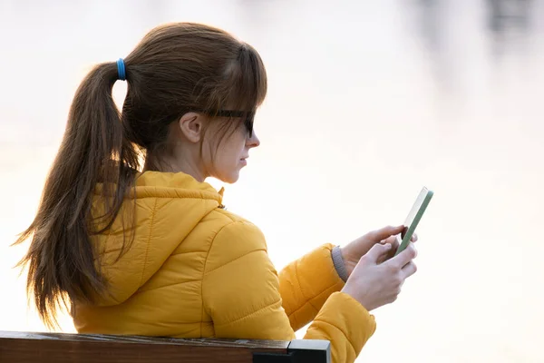 Молодая Красивая Женщина Сидит Скамейке Парке Просматривая Свой Смартфон Открытом — стоковое фото